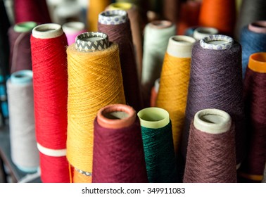 Colorful Assortment Of Vivid Colors Of Cotton Spools On Cardboard Cones For Use In The Knitwear And Garment Industry Viewed High Angle