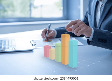 Colorful augmented reality bar graph floating above the desktop surface showing business performance or financial information for investment - Powered by Shutterstock