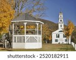 Colorful autumn scene in rural New Hampshire. Charming and picturesque village of Wentworth with town common, gazebo, and historic church with tall white steeple.