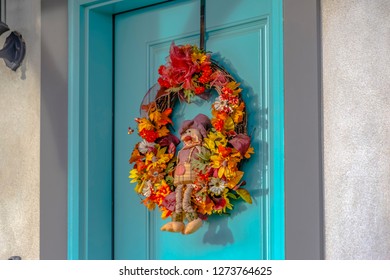 A Colorful Autumn Wreath With Small Scarecrow