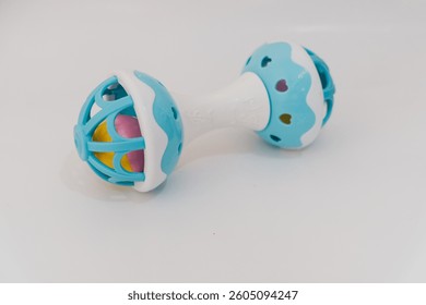 Colorful baby rattle, a baby toy shaped like a dumbbell, made of plastic and can make sounds on white isolated white background.