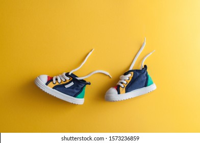 Colorful baby shoes on bright yellow background in child's room - Powered by Shutterstock