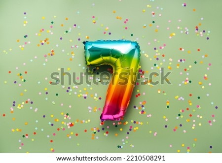 Colorful balloon number 7 on light green background. New Year of birthday concept