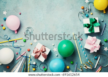 Colorful balloon, present or gift box, confetti, candy and streamer on vintage turquoise table top view. Birthday or party background. Flat lay style. Copy space for text.