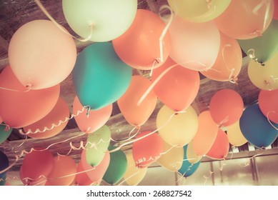 Colorful balloons floating on the ceiling of a kid party celebration in vintage retro color style