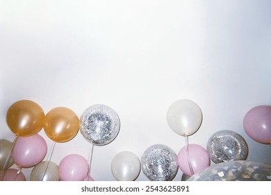 Colorful balloons, including pink, silver, and gold, float against a white background. Festive balloons create a cheerful, celebratory atmosphere. Ballon for celebration and party. - Powered by Shutterstock