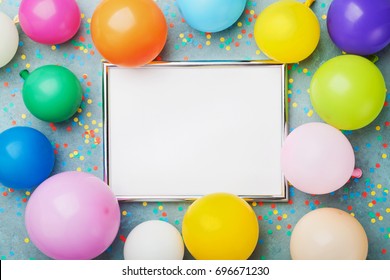 Colorful Balloons, Silver Frame And Confetti On Blue Background Top View. Birthday Or Party Mockup For Planning. Flat Lay Style. Copy Space For Text. Festive Greeting Card.