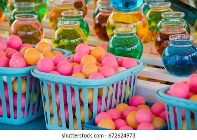 colorful balls in basket with water in glass bowls for carnival game