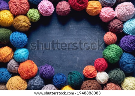 Colorful balls of wool on wooden table. Variety of yarn balls, view from above.