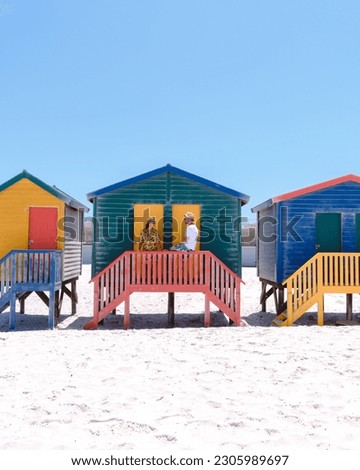 colorful beach house at Muizenberg beach Cape Town, beach huts, Muizenberg, Cape Town, False Bay, South Africa. Couple of men and women on the beach during vacation in Cape Town during summer