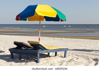 Colorful beach lounge chairs and umbrella along the Mississsippi Gulf Coast.