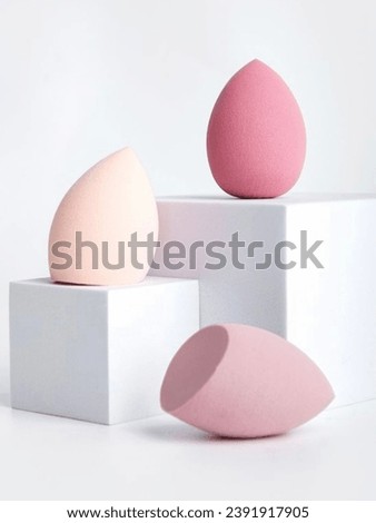 Colorful beauties sponges  on a white background and stand on a geometric podium. beauty concept beauty blender Cosmetic tools for applying Mix and apply foundation Concealer copy space for text