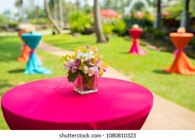 colorful beautiful orchid bouquet decor in glass vase setup on wooden dinner table in india wedding venue reception. - Powered by Shutterstock