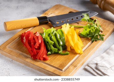 Colorful bell peppers sliced on cutting board. - Powered by Shutterstock