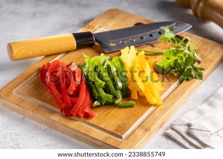 Colorful bell peppers sliced on cutting board.