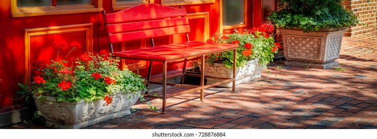 A Colorful Bench And Flowers On The Cobblestone Sidewalks In Northern Virginia.