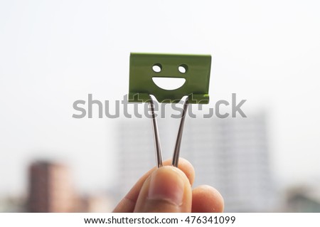 Colorful binder clip woman's hand in to sky background, selective focus and soft focus