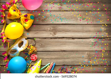 Colorful birthday or carnival frame with party items on wooden background