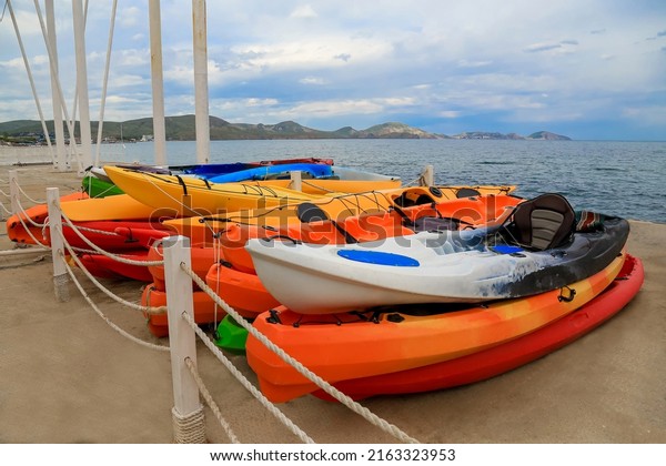 colorful boats, surfers, kayaks, paddleboards,\
canoes, water sports, outdoor activities, sea, ocean, river,\
rafting, extreme travel, place for text, water transport warehouse,\
paddle, sea travel,\
pier