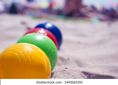 Colorful Bocce Balls Lying In A Row On The Beach With Blurred Background, Low View