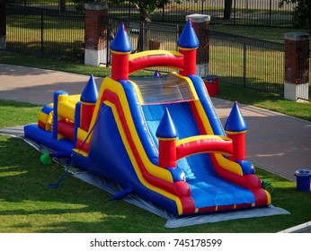 Colorful bouncy castle sitting on a grassy park  - Shutterstock ID 745178599