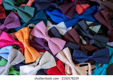 Colorful bow ties texture, pile of bow ties spilled on the floor, top view neck tie backdrop, lay down man fashion concept