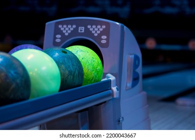 Colorful Bowling Balls On Stand. Close Up On Ball Return At Bowling Club