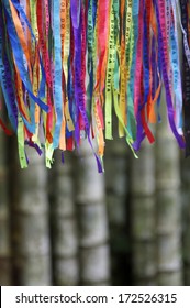 Colorful Brazilian Carnival lembranca wish ribbons against bamboo forest background