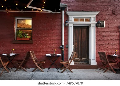 ein buntes Ziegelgebäude mit Tischen und Stühlen in einem typischen Viertel von Brooklyn, New York City