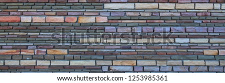 Colorful brick wall. Background of multicolored stone wall texture, panorama 