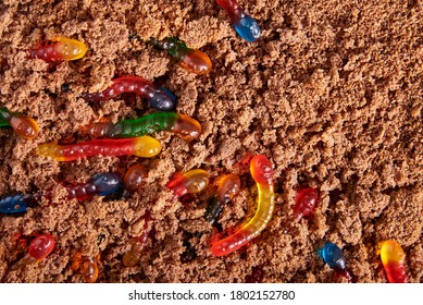 Colorful And Bright Assorted Gummy Worms In Chocolate Cake Ground, Halloween Party Food, Copy Space