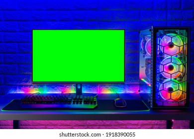 Colorful Bright Illuminated Rgb Gaming Pc With Keyboard Mouse Monitor With Green Screen Copy Space In Front Of LED Light Brick Stone Wall. Computer Playing Hardware Games Background