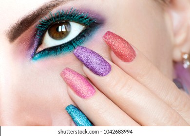 Colorful bright makeup on brown eye close-up.Color turquoise mascara.Peacock eye.Nail extension.