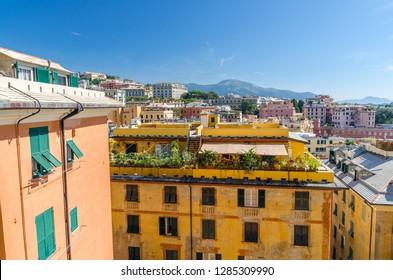 Colorful buildings on hill in city district of Genoa Genova and Monte Fasce mountain of Ligurian Appennines range with blue clear sky background, view from Belvedere Castelletto, Liguria, Italy