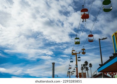 colorful cable cars from below on cloudy blue sky background at the santa cruz boardwalk , california, usa - Powered by Shutterstock