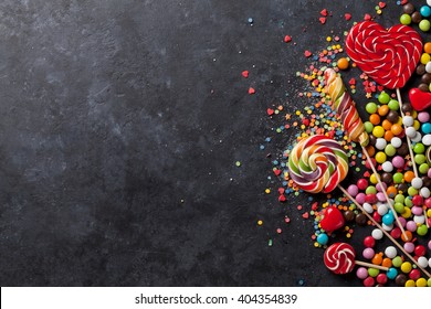 Colorful candies and lollipops over stone background. Top view with copy space - Powered by Shutterstock