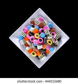 Colorful candy in plain white dish. Liquorice allsorts in many colors and shapes. Filter effects.