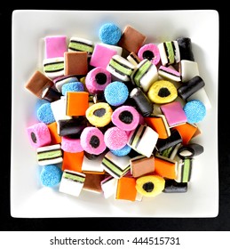 Colorful candy in plain white dish. Liquorice allsorts in many colors and shapes. Filter effects.