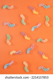 Colorful Candy Worm Pattern. Halloween Trick Or Treat Minimal Concept On Orange Background.