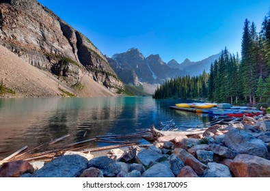 Colorful canoes and reflecting waters of Moraine Lake in Banff National Park Alberta Canada