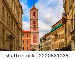 The colorful Caserne Rusca clock tower and traditional buildings in the streets of the Old Town Vieille Ville in Nice, French Riviera, South of France
