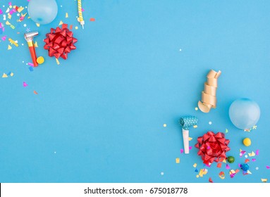 Colorful celebration pattern with various party confetti, balloons and red bows on blue background. Flat lay