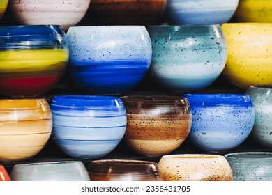 Colorful ceramic bowls stacked on a potters market stall - Brightly colored background - Powered by Shutterstock