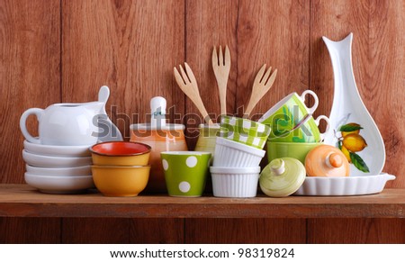 colorful ceramic kitchen utensils on wooden shelf