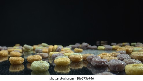 Colorful Cereal Hoops reflect on a glossy black surface. Healthy multicolored cereal on black background. Food concept. - Powered by Shutterstock