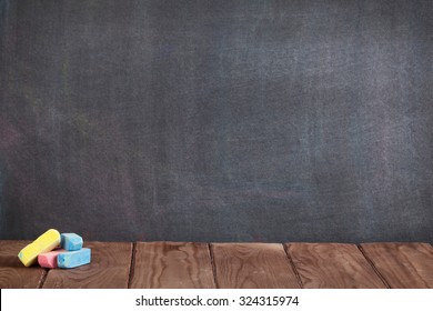 Colorful chalks on classroom table in front of blackboard. View with copy space - Powered by Shutterstock