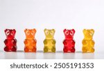 colorful, chewy, edible gummy bears. Gelatin form factor vitamins, chewable supplements, edible health candy. Fruit flavors set of delicious snacks isolated on white background with copy space