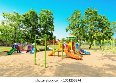 Colorful children playground activities in public park surrounded by green trees