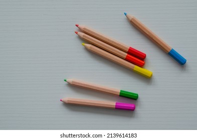 Colorful Children's Mini Pencils On A White Wooden Background. School And Kindergarten Art Supplies.