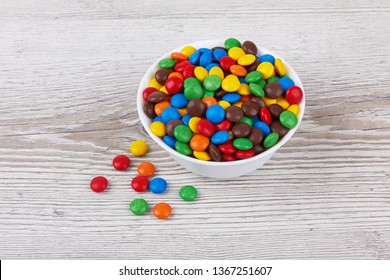 colorful chocolate buttons on wooden background